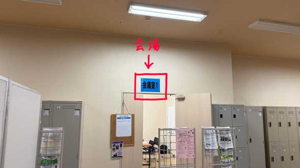 青い背景に「会議室1」と書かれた部屋